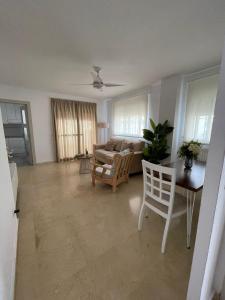 a living room with a couch and a table and chairs at El Portil Pinares in El Portil