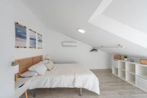 a white bedroom with a bed and white shelves at Dúplex Bellas Vistas in Ojén +14 photos