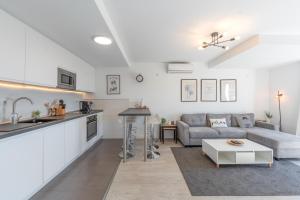 a kitchen and living room with a couch and a table at Dúplex Bellas Vistas in Ojén