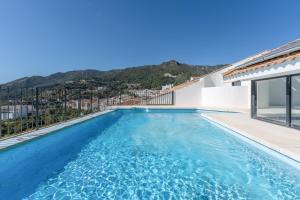 a swimming pool in a villa with mountains in the background at Dúplex Bellas Vistas in Ojén