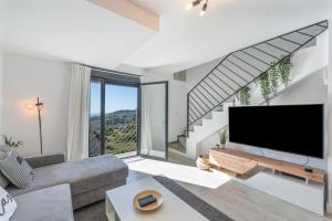 a living room with a large flat screen tv at Dúplex Bellas Vistas in Ojén