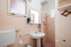 a bathroom with a sink and a toilet and a window at Villa Privata Spiaggia Del Sole in Porto Cesareo +25 photos