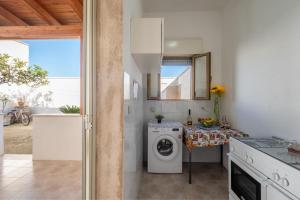 a kitchen with a washing machine and a table at Villa Privata Spiaggia Del Sole in Porto Cesareo
