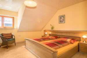 a bedroom with a bed and a chair at Ferienwohnung Monninger in Langenargen