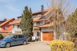 a blue car parked in front of a house at Ferienwohnung Monninger in Langenargen