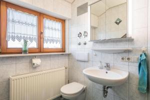 a white bathroom with a sink and a toilet at Ferienwohnung Monninger in Langenargen +15 photos