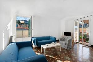 a living room with a blue couch and a table at Casa Terrazza Marino in Levanto