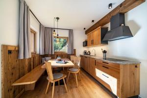 a kitchen with wooden cabinets and a table and chairs at Grogg 608 Apt I in Martello +13 photos