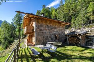 a log cabin with a table and benches in the yard at Grogg 608 Apt I in Martello