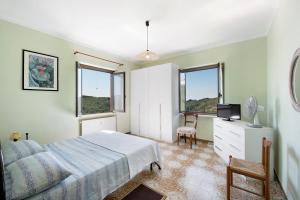 a bedroom with a bed and a tv and windows at Casa Vera in Gavi