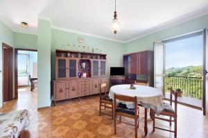 a dining room with a table and a balcony at Casa Vera in Gavi