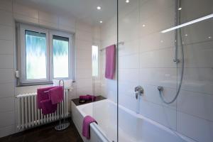 a white bathroom with a tub and a shower at Ferienhaus Hulda in Öhningen +33 photos