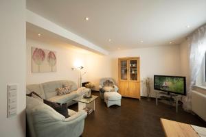 a living room with two couches and a flat screen tv at Ferienhaus Hulda in Öhningen