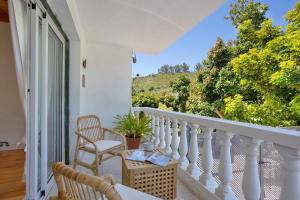 a white balcony with a table and chairs and a window at Picarus Home in Tacoronte