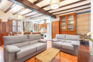 a living room with two couches and a kitchen at Cueva Del Sereno in Chulilla