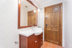 a bathroom with a sink and a mirror and a door at Cueva Del Sereno in Chulilla +12 photos