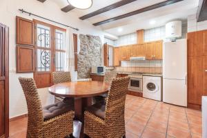 a kitchen with a wooden table and chairs at Cueva Del Sereno in Chulilla