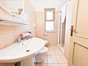 a bathroom with a sink and a toilet and a mirror at Appartamenti Le Querce App. Mirto in Capoliveri