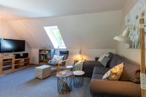 a living room with a couch and a tv at Ferienhof An Der Wehle Pellworm in Pellworm