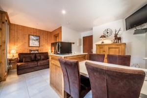 a kitchen and living room with a table and chairs at Au Rêve Savoyard 1 - 2 personnes in Morillon +21 photos