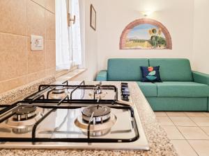 a stove top oven in a kitchen with a couch at Appartamenti Le Querce App. Mirto in Capoliveri