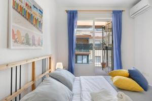 a bedroom with a bed and a window with blue curtains at Camaleón 7 in Chipiona +21 photos