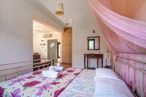a bedroom with a large bed with a pink canopy at Alkionides Apartment 1 in Agios Nikitas