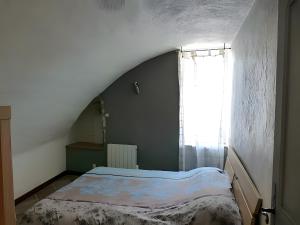 a bed in a room with a large window at L'alouette - Gites Rocheflamme in La Malène