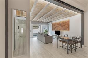 a living room and dining room with a brick ceiling at El racó del Mas in Canet de Mar