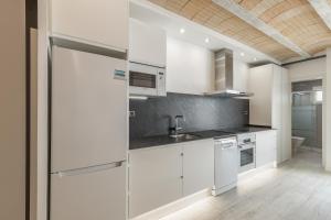 a kitchen with white cabinets and a sink at El racó del Mas in Canet de Mar +20 photos