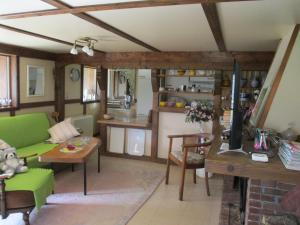 a living room with a green couch and a table at Altes Jägerhaus in Lübbenow