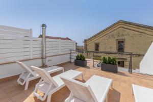 a patio with white tables and chairs on a roof at El racó del Mas in Canet de Mar