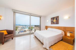 a bedroom with a bed and a large window at Casa Mulet in Can Picafort