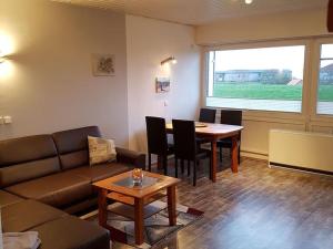 a living room with a couch and a table at Ferienwohnung Meerblick in Wangerland +5 photos