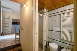 a bathroom with a toilet and a tile wall at Ca Lindaria in Bonassola +18 photos