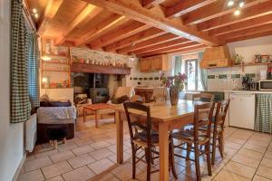 a kitchen with a table and chairs in a room at Maison cosy, 5 mins de St Lary in Sailhan +13 photos