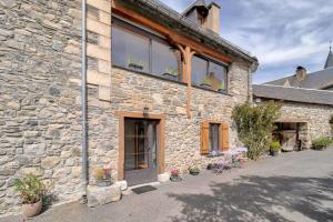 a stone building with windows and potted plants on it at Maison cosy, 5 mins de St Lary in Sailhan