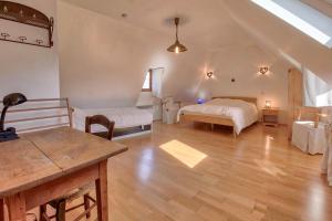 a large room with two beds and a table at Maison cosy, 5 mins de St Lary in Sailhan