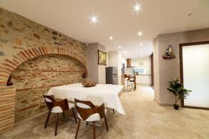 a dining room with a table and a brick wall at Plaisir des pierres in Rivesaltes +12 photos
