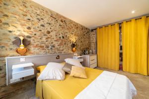 a bedroom with a bed and a stone wall at Plaisir des pierres in Rivesaltes