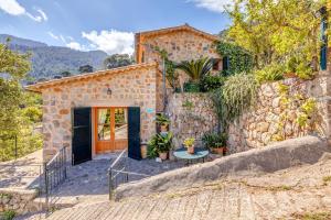 a stone house with a gate and a stone wall at Casa Catalina in Sóller