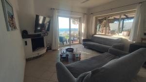 a living room with a couch and a television at Costa dei Monaci Villas - Tropea in Parghelia