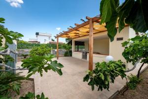 an outdoor patio with a wooden pergola at Villa Minetta in Leporano Marina