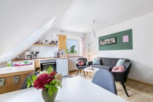 a kitchen and living room with a couch and a table at Ferienhaus Dohle in Vollerwiek