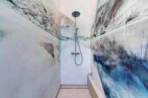 a shower in a bathroom with paintings on the walls at Gästehaus Achern in Achern +15 photos