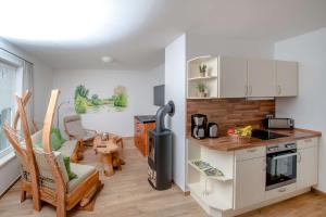 a kitchen and living room with a stove and a table at Ferienwohnung Fliess in Neuendorf am See