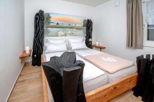 a bedroom with a bed with a painting on the wall at Ferienwohnung Fliess in Neuendorf am See