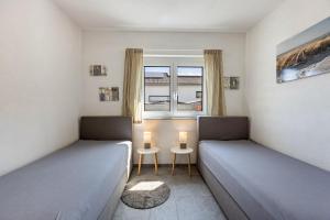 two beds in a small room with a window at Fewo Aida in Stockach