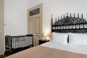 a bedroom with a large bed with a black headboard at Sé Heritage in Angra do Heroísmo