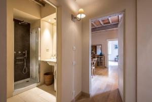 a bathroom with a walk in shower next to a hallway at Radicondoli House in Radicondoli +20 photos